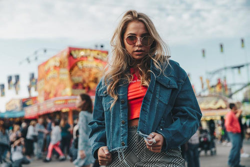 Woman wearing a denim jacket at an amusement park